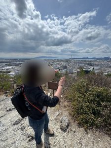 山の中腹で風景の写真を撮るイケダ